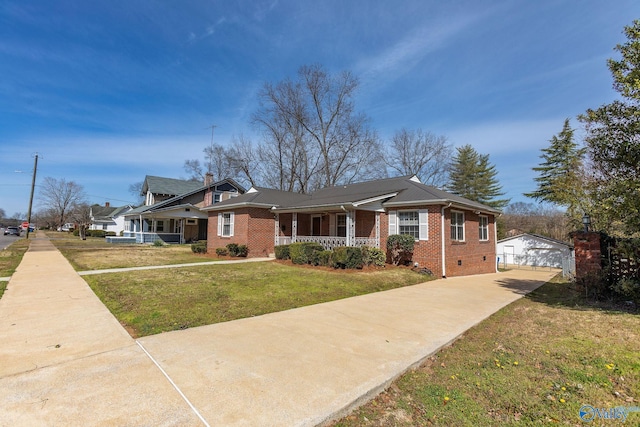 view of front of house with covered porch, an outdoor structure, a front yard, a garage, and brick siding