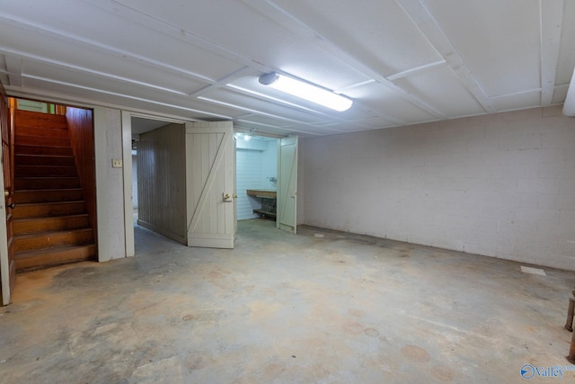 finished basement with concrete block wall and stairs