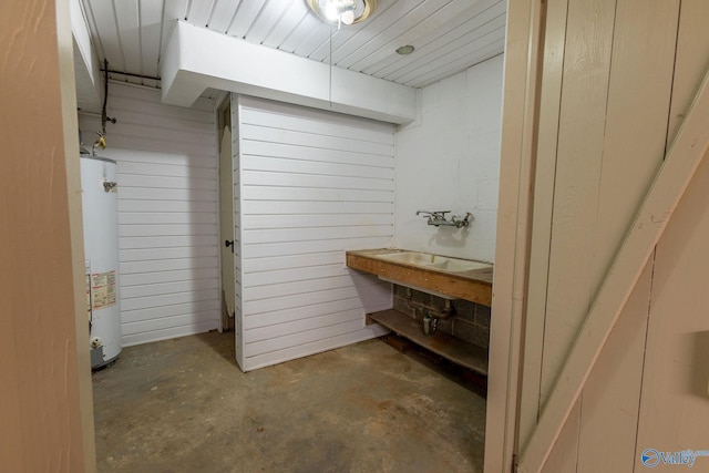 bathroom with concrete floors and water heater