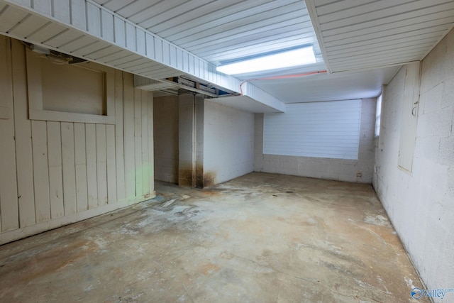 interior space with unfinished concrete floors and concrete block wall