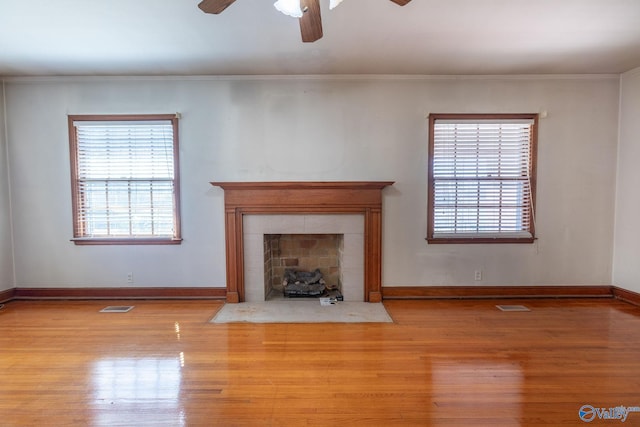 unfurnished living room with visible vents, wood finished floors, and crown molding