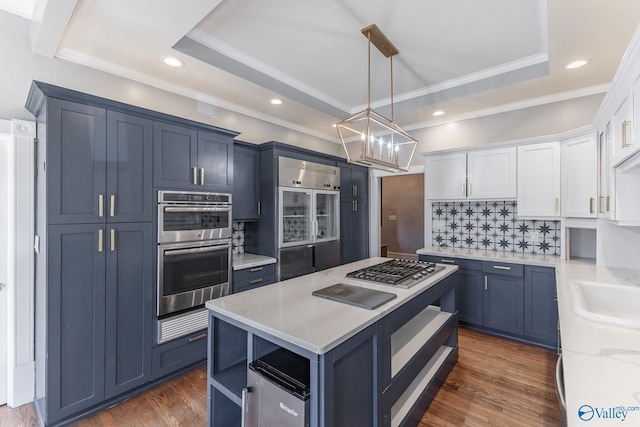 kitchen featuring dark wood-type flooring, backsplash, double oven, white cabinets, and a raised ceiling