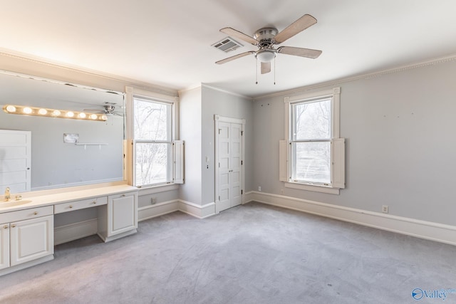 unfurnished bedroom featuring visible vents, multiple windows, ornamental molding, and built in study area