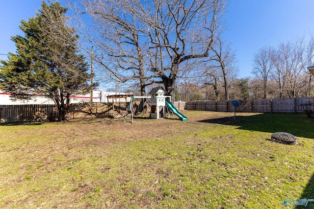 view of yard with a fenced backyard and a playground