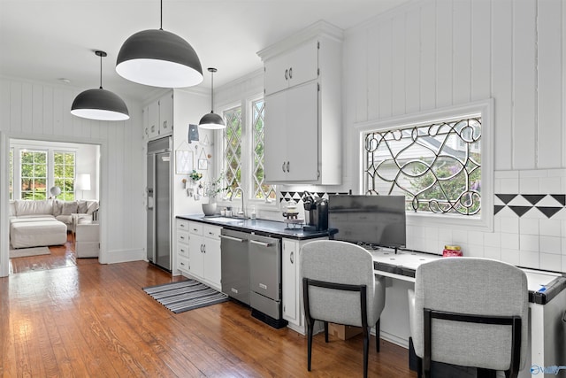 702 5th Ave SE, Cullman, AL 35055 - kitchen with wood finished floors, decorative backsplash, a sink, and stainless steel appliances