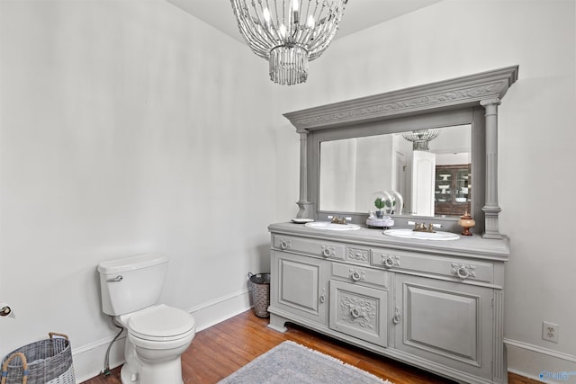 702 5th Ave SE, Cullman, AL 35055 - bathroom with a notable chandelier, baseboards, a sink, and wood finished floors