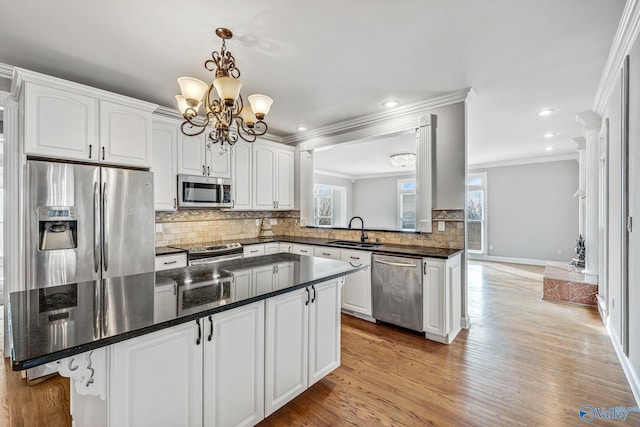 kitchen with stainless steel appliances, white cabinetry, sink, and backsplash