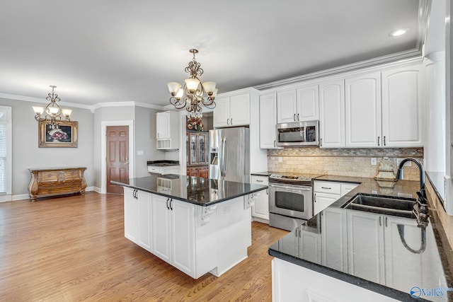 kitchen with white cabinetry, sink, stainless steel appliances, and hanging light fixtures