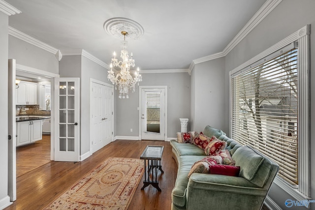 living room featuring ornamental molding, dark hardwood / wood-style floors, and a notable chandelier