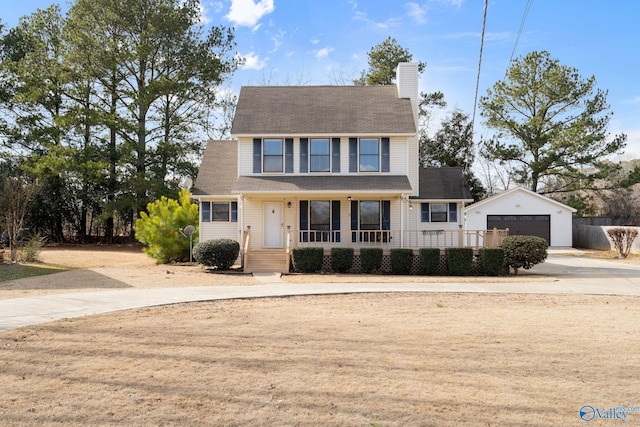 colonial home with an outbuilding, a garage, and covered porch