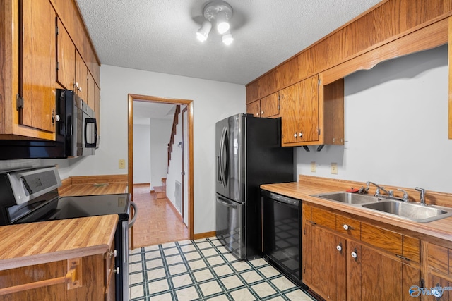 kitchen featuring sink, a textured ceiling, and black appliances