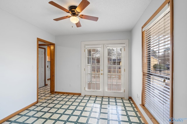 unfurnished room featuring ceiling fan, a textured ceiling, and french doors