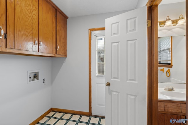 washroom featuring washer hookup, sink, and cabinets