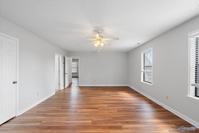 spare room with ceiling fan, dark wood-type flooring, and a textured ceiling