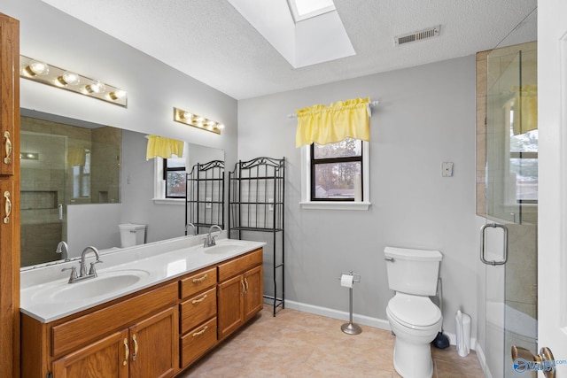 bathroom with toilet, an enclosed shower, a textured ceiling, and a skylight