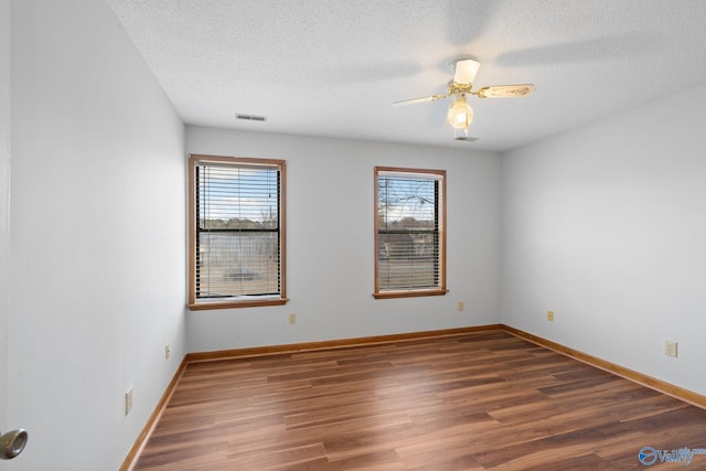 spare room featuring ceiling fan, dark hardwood / wood-style floors, and a textured ceiling