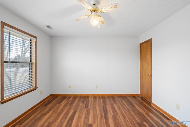 spare room featuring ceiling fan, dark hardwood / wood-style flooring, and a textured ceiling