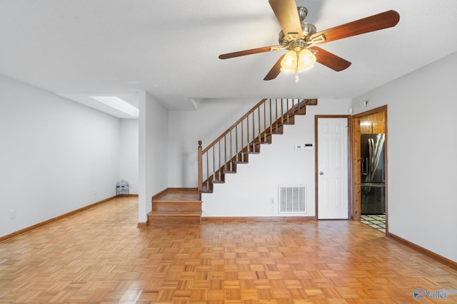 interior space featuring ceiling fan, light parquet flooring, and a textured ceiling