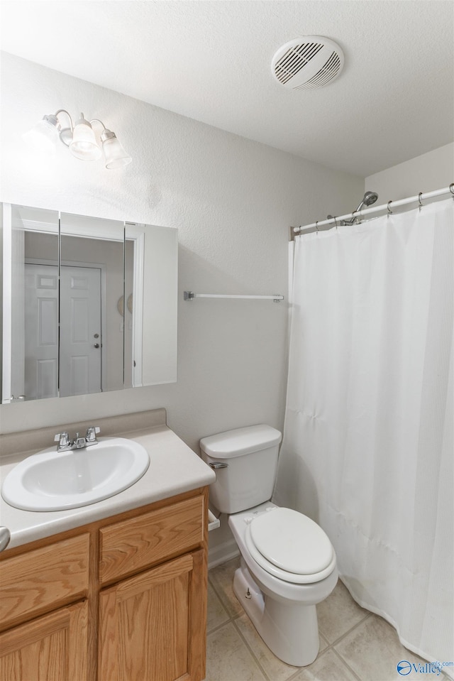 bathroom featuring tile patterned flooring, curtained shower, vanity, and toilet