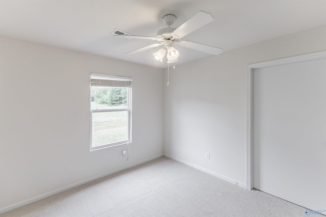 carpeted spare room featuring ceiling fan