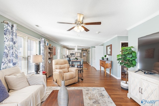 living area featuring ornamental molding, visible vents, a textured ceiling, and wood finished floors