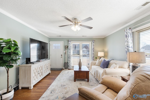 living room with visible vents, ornamental molding, ceiling fan, a textured ceiling, and wood finished floors