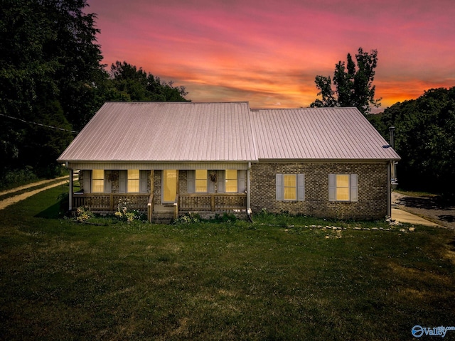 view of front of house featuring covered porch and a lawn