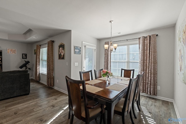 dining area with a notable chandelier and dark hardwood / wood-style floors