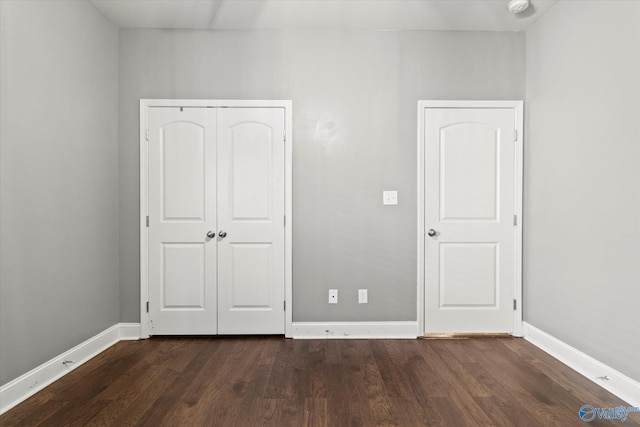 unfurnished bedroom featuring dark hardwood / wood-style flooring and a closet