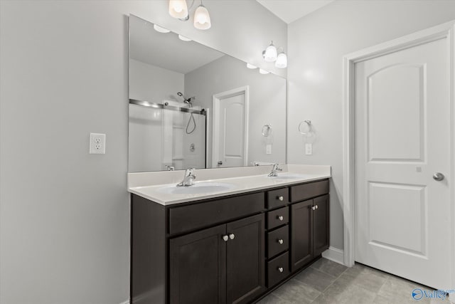 bathroom with tile patterned floors, vanity, and a shower with door