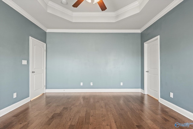 spare room featuring crown molding, ceiling fan, a tray ceiling, and dark hardwood / wood-style flooring