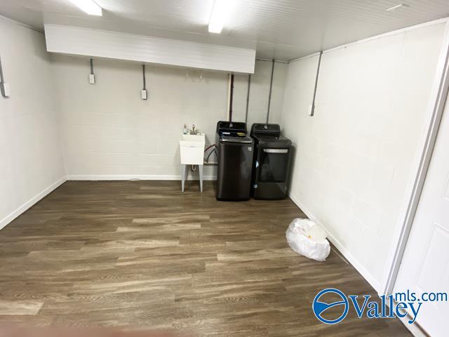 basement with dark hardwood / wood-style floors, separate washer and dryer, and sink