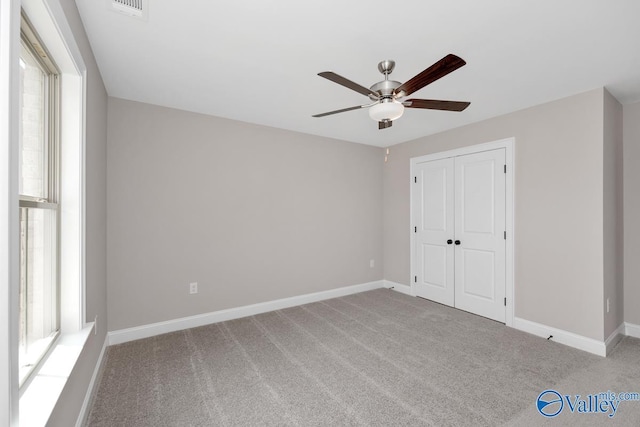 unfurnished bedroom featuring carpet flooring, ceiling fan, and a closet