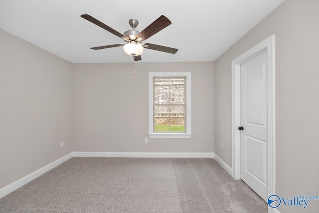 carpeted spare room featuring ceiling fan