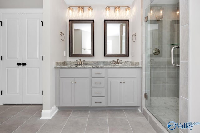 bathroom featuring a shower with door, vanity, and tile patterned flooring