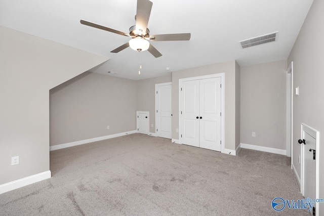 additional living space featuring light carpet and ceiling fan