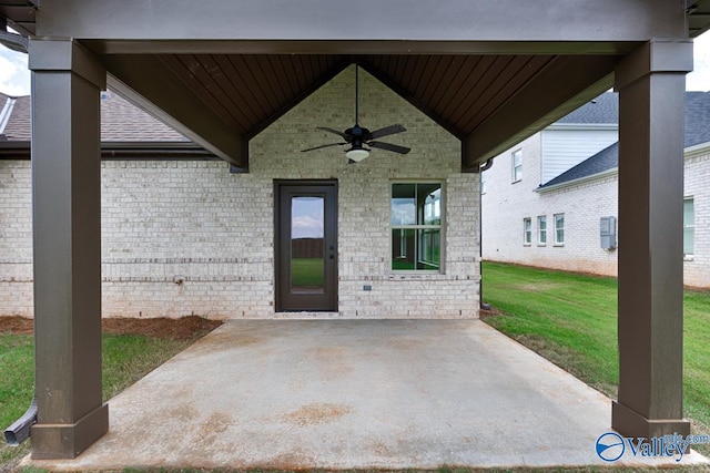 entrance to property featuring a yard, a patio, and ceiling fan