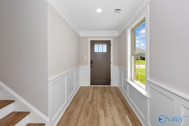 doorway to outside featuring crown molding and light wood-type flooring