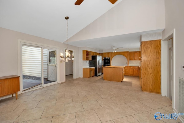 kitchen featuring a center island, high vaulted ceiling, stainless steel fridge, pendant lighting, and light tile patterned floors