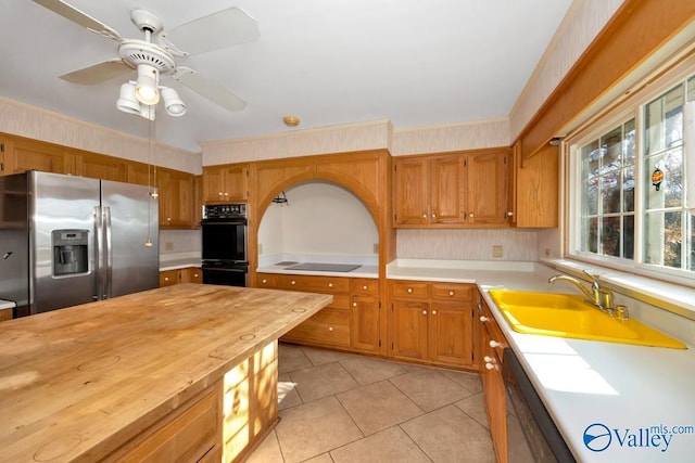 kitchen featuring wood counters, electric cooktop, sink, ceiling fan, and stainless steel fridge with ice dispenser