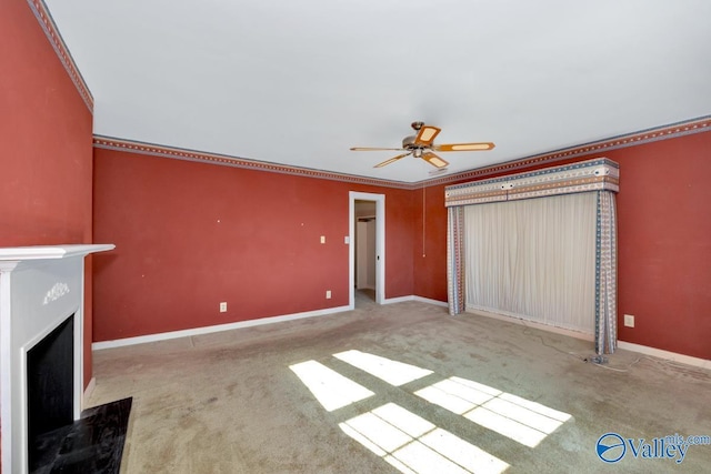 unfurnished living room featuring ceiling fan, carpet floors, and crown molding