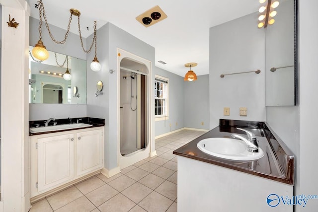 bathroom featuring vanity, tile patterned floors, and a shower with shower door