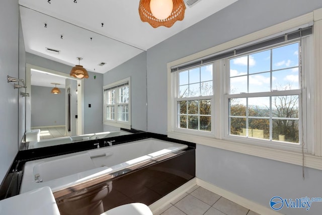 bathroom with tile patterned floors and a healthy amount of sunlight