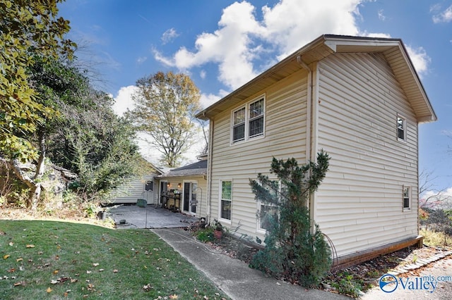 view of home's exterior with a patio and a lawn