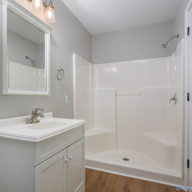 bathroom featuring hardwood / wood-style floors, vanity, and a shower