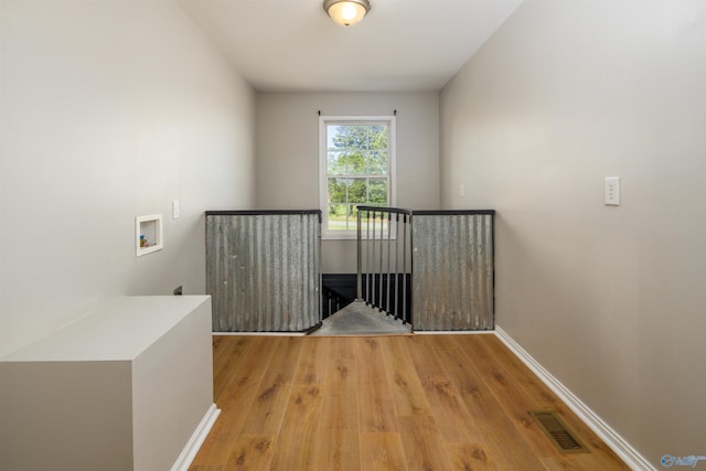 corridor with light hardwood / wood-style floors