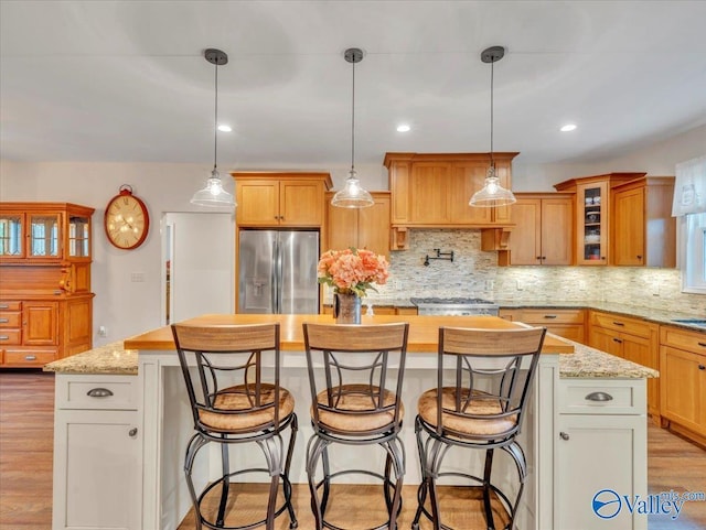 591 Nix Rd, Hazel Green, AL 35750 - kitchen featuring appliances with stainless steel finishes, light wood-style floors, a center island, tasteful backsplash, and glass insert cabinets