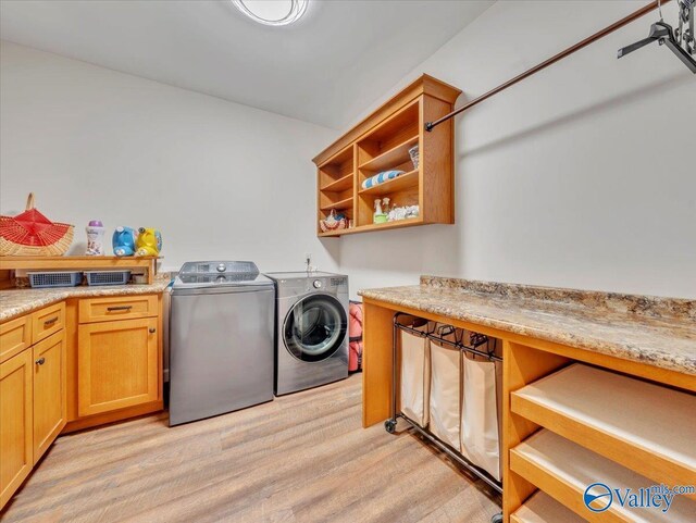 591 Nix Rd, Hazel Green, AL 35750 - clothes washing area with washer and clothes dryer, light wood finished floors, and cabinet space