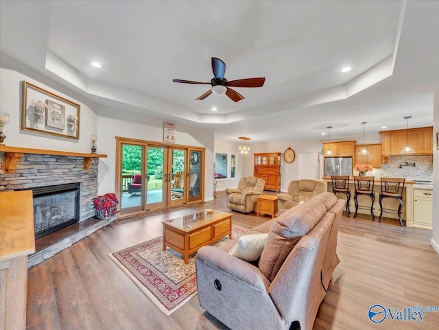 591 Nix Rd, Hazel Green, AL 35750 - living room with a tray ceiling, light wood-style floors, ceiling fan, recessed lighting, and a fireplace