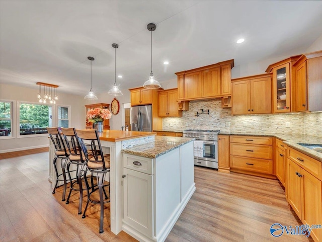591 Nix Rd, Hazel Green, AL 35750 - kitchen featuring appliances with stainless steel finishes, decorative backsplash, light wood-type flooring, glass insert cabinets, and recessed lighting